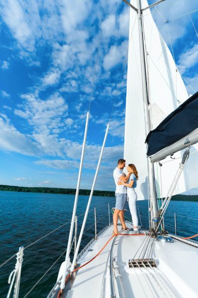 couple-on-yacht-hugging-sailing-at-seaside-enjoying-vacation-vertical-1.jpg